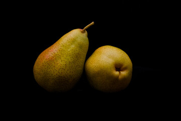 Pair of ripe pears on black background