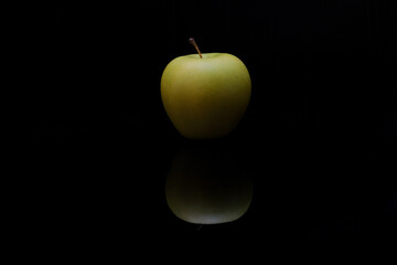 Green apple with reflection on dark background