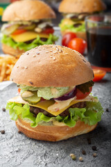 Burgers with a drink. Vertical photo of burgers. Three burgers with a drink.