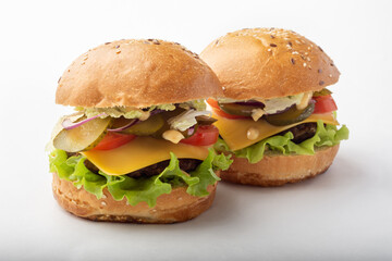 Classic burgers on a white background for isolation. Burgers with cucumbers and onions. Two burgers on a white background