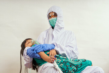 Pediatrician doctor wearing protective suit takes care of child patient , coronavirus protection concept