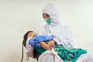 Pediatrician doctor wearing protective suit takes care of child patient , coronavirus protection concept