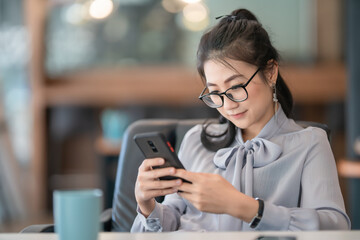 Young Asian beautiful woman using smart phone for business.