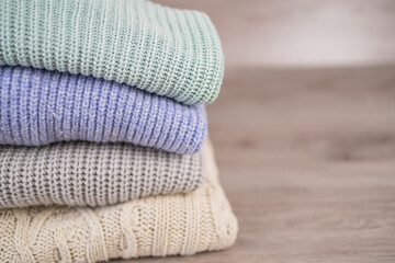 a stack of warm cozy woolen sweaters jersey jumpers for the winter