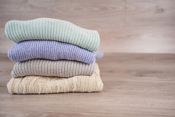 a stack of warm cozy woolen sweaters jersey jumpers for the winter