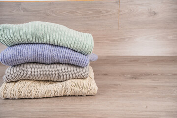 a stack of warm cozy woolen sweaters jersey jumpers for the winter