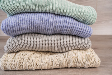 a stack of warm cozy woolen sweaters jersey jumpers for the winter