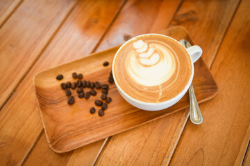 Coffee cup on wooden table in cafe with coffee beans background, Cappuccino or latte coffee.
