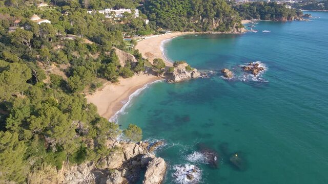 aerial image with drone of lloret de mar virgin beach with green vegetation in mediterranean sea  turquoise water