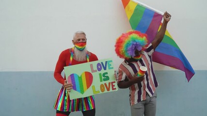 Activist people with different age and ethnicity having fun celebrating gay pride festival dancing and protesting for gender equality - LGBT social movement concept