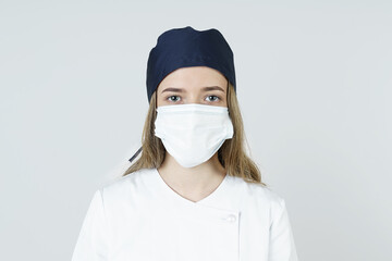 Medicine and health concept. Portrait of a young female doctor wearing a mask and headdress.