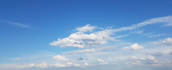 Bright blue sky with clouds above horizon
