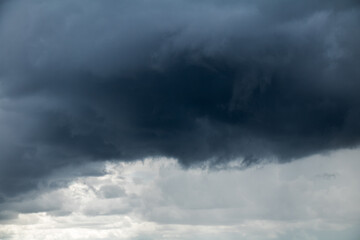 Fototapeta na wymiar Light sky with impending ominous black cloud