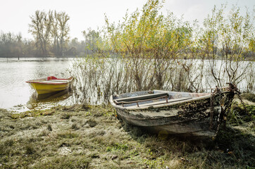 Naklejka na ściany i meble Novi Sad, Serbia - November 15. 2020: A forgotten fishing boat in the tributary of the Danube near Novi Sad, Serbia 