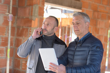 Architect and contractor looking at plans on a building site