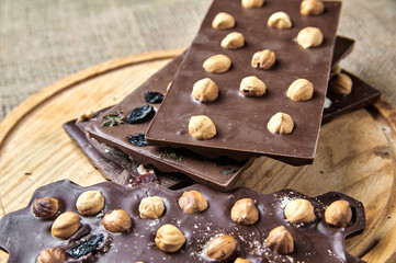Chocolate bar with nuts on wood background