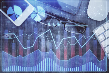 Multi exposure of forex graph hologram over desktop with phone. Top view. Mobile trade platform concept.