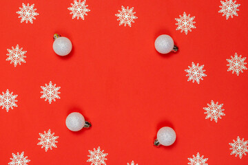Winter pattern. Silver balls, white snowflakes in shape frame on red background for greeting card. Christmas, winter, new year concept.