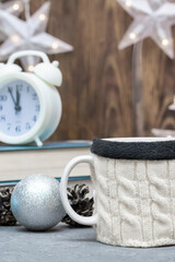 Mug with hot drink in knitted wool cover. Winter composition, home comfort. Selective focus, fog view