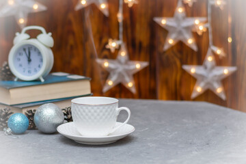 White cup and saucer in winter composition. Hot drink on table. Selective focus, fog view