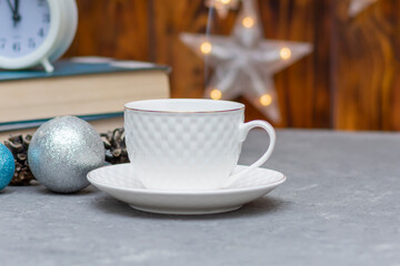 White cup with hot tea or coffee in winter composition. Christmas and New Year concept. Selective focus, fog view