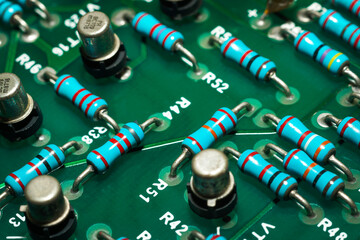 Closeup on electronic devices on boards, background images.Colored electronic components. Resistors, transistors, capacitors and integrated circuit on PCB. Standard color code. 