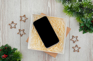 Christmas mockup with smartphone. Christmas tree and  phone in a box. Christmas and New Year shopping on the Internet.