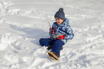Fototapeta na wymiar little boy sitting in the snow