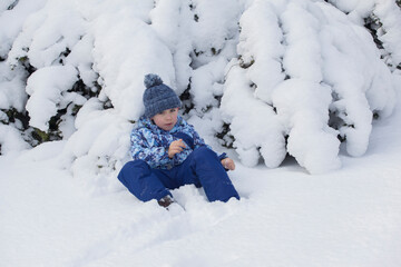 Fototapeta na wymiar little boy sitting in the snow