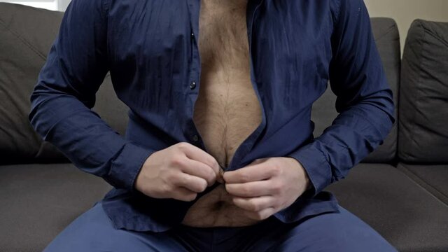 Overweight man tries unsuccessfully to button his shirt. Overweight problem.