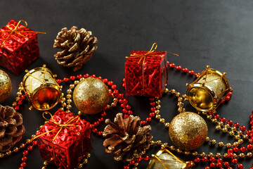 Christmas decorations in gold and red on a black background with free space.