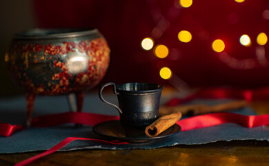 Christmas still life. Coffee, cinnamon, lights. Cozy atmosphere. 