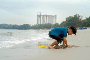 A young boy playing sand at the beach - close up photo of the sand.