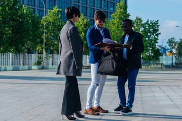 Fototapeta premium Group of successful business people discussing work outside their office building.