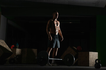 Fototapeta na wymiar Silhouette of a fit strong shirtless athlete doing squats. Weight lifting workout concept.