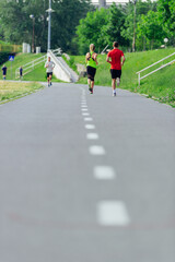 Rearview of caucasian female and male running outdoors on a road