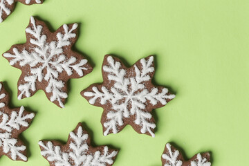 Snowflake gingerbread cookies on green background.