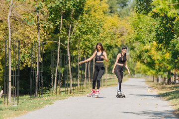 Full-length picture of sexy sportswomen rollerskating in the park