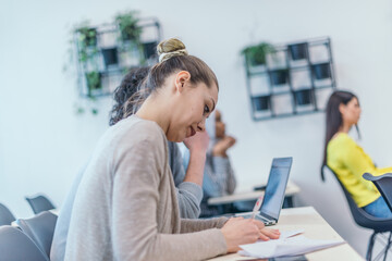  Multi-ethnic business group listening to a speaker while attending a business seminar at a modern workshop...