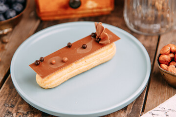 Traditional French eclairs with cream. Eclairs decorated with chocolate and berries on a plate.