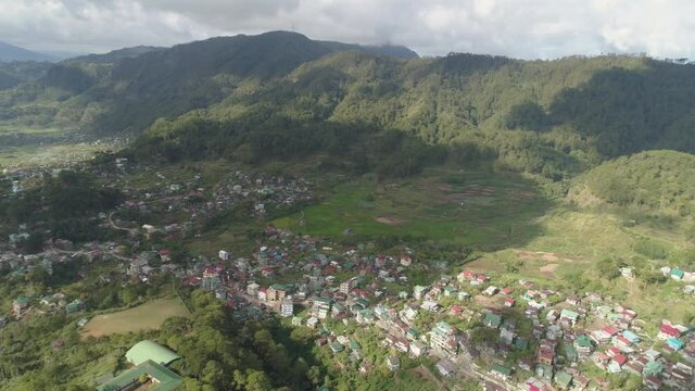 Aerial view town Sagada, located in mountainous province of Philippines. City in valley among mountains covered with forest.