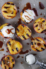 Ice cream balls on the halves of baked peaches with honey and coarse sea salt. 