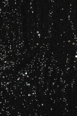 Black sparkling glitter background with tinsel confetti. Christmas. New Year holidays celebration minimalistic concept.