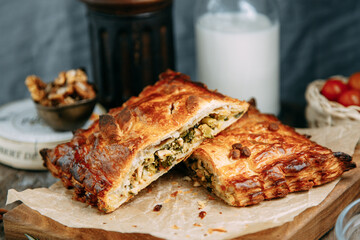 Hot chicken puff pastry pie. Pie with vegetables on a wooden table.