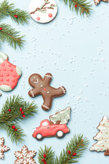Beautiflly decorated gingerbread cookies on wintery blue background. Tasty homemade Christmas cookies close up view. 
