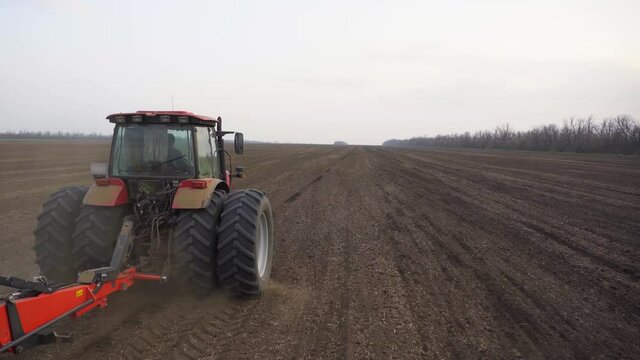 Agriculture. Aerial video shooting. Trailed mechanical seeder. Kuhn. Spring sowing. Sowing the field. Tractor MTZ