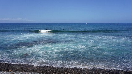 Seashore of Playa de Las Americas, Tenerife, Canary Islands, Spain, waves in the ocean on a sunny summer day. 