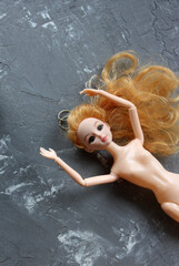 plastic doll on grey background