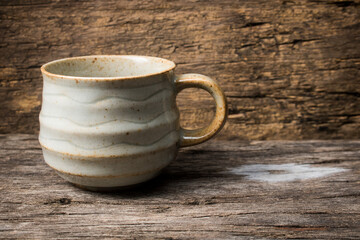 handmade ceramic coffee cup on wooden table.