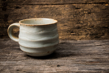 handmade ceramic coffee cup on wooden table.